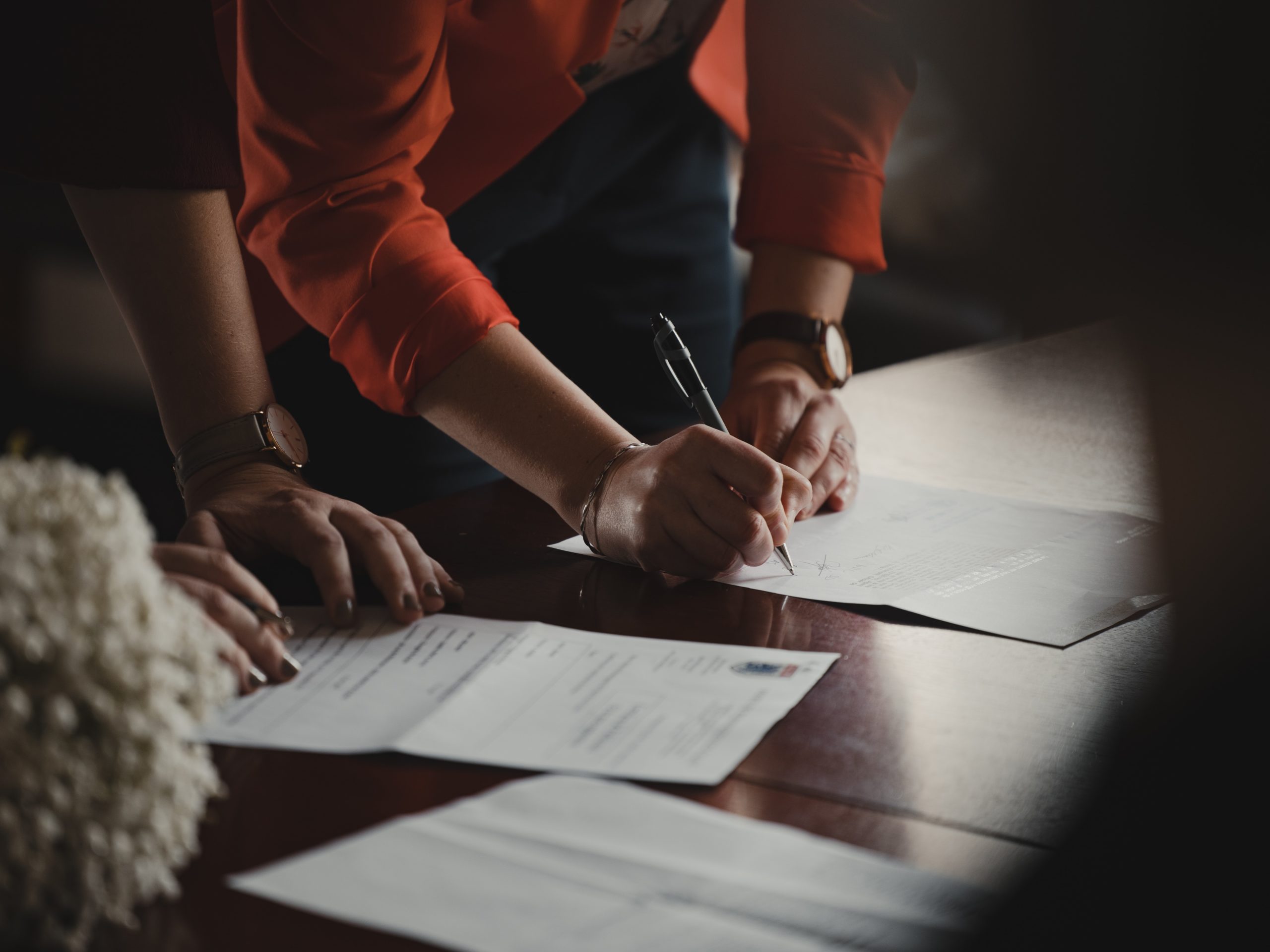 two people are signing some documents